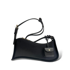 Multi-Tone Asymmetrical Curved Slim Shoulder Carry Vessel Diminutive Snap Pouch Dangling Accent and Sleek Sealed Top Track Handbag